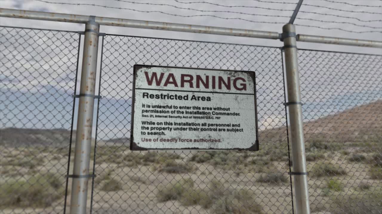 High quality 3D CGI render with a smooth dollying-out shot of a chainlink fence at a high security installation in a desert scene, with a Warning Restricted Area sign