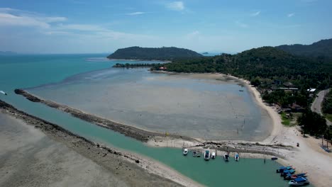 Channel-to-Harbor-on-Ko-Samui-Thailand-Island-at-low-tide---aerial-fly-out-to-sea