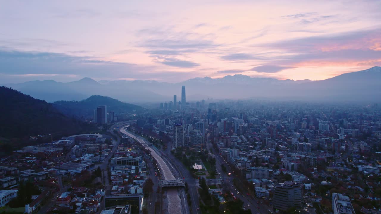Aerial view dolly out establishing of Santiago Chile at dawn with orange and purple colors Mapocho river