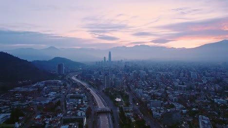 vista aérea dolly fuera del establecimiento de santiago chile al amanecer con colores naranja y púrpura río mapocho