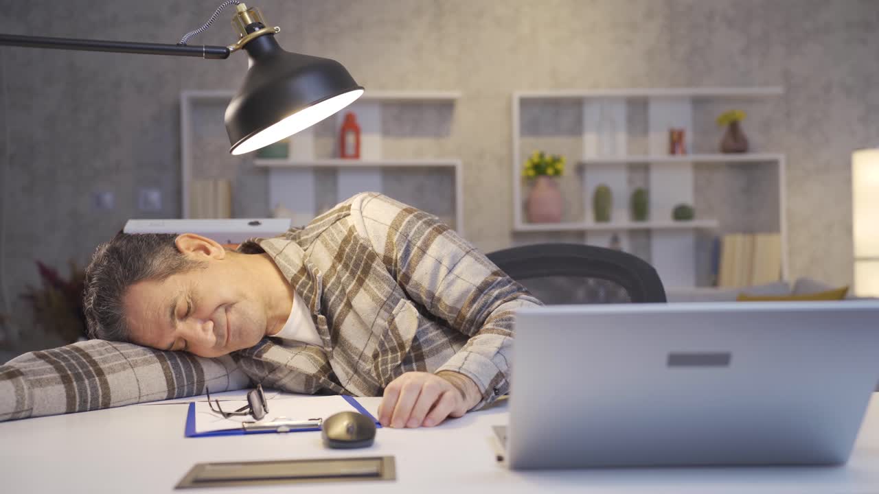 홈 오피스에서 일하는 성숙한 남자는 지루하고 일하고 싶지 않습니다.