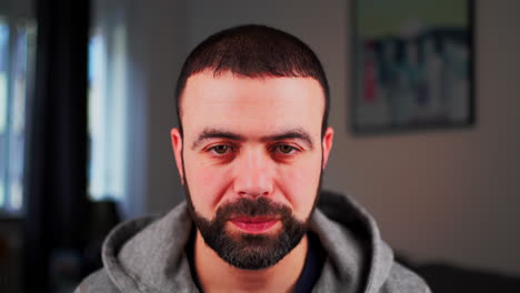 retrato de un hombre barbudo sonriendo a la cámara