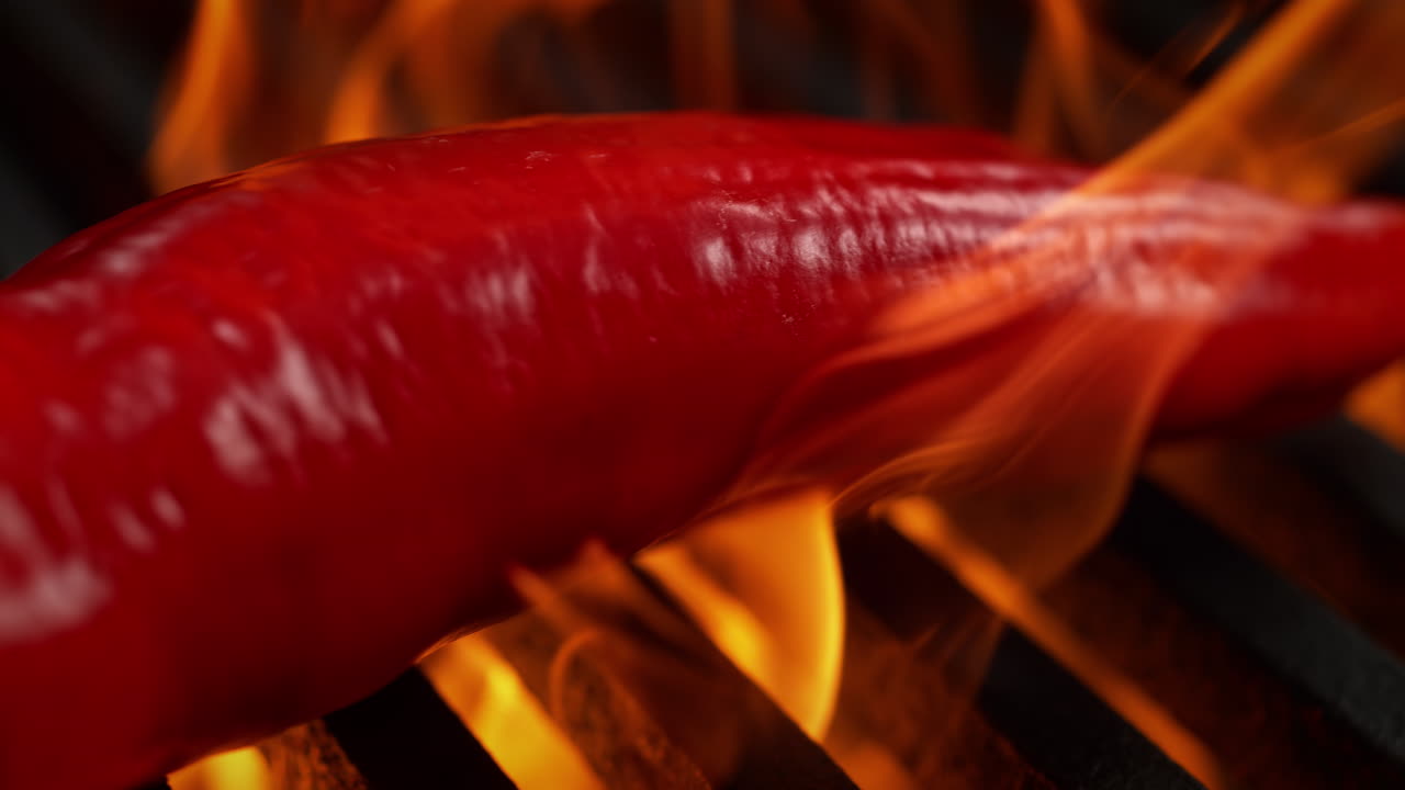 Long Red Pepper Barbecued On A Grill, Roasted By Flames Beneath The Grill Grate, Macro and Slow Motion