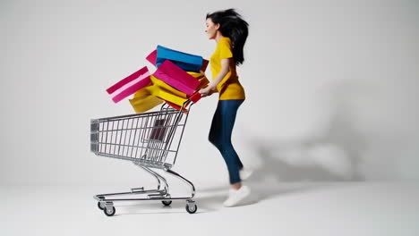woman running with shopping cart full of shopping bags