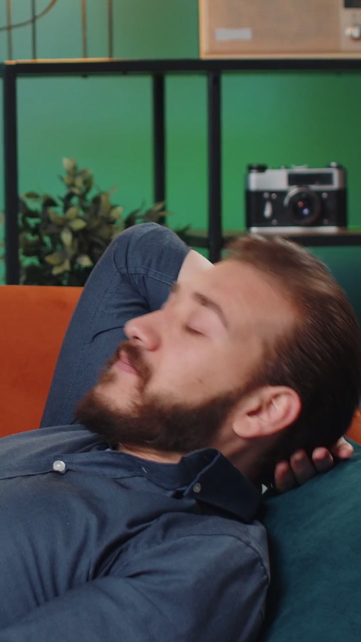 Homem libanês cansado deitado em um sofá confortável tomando uma sesta diurna descansando relaxando adormecendo