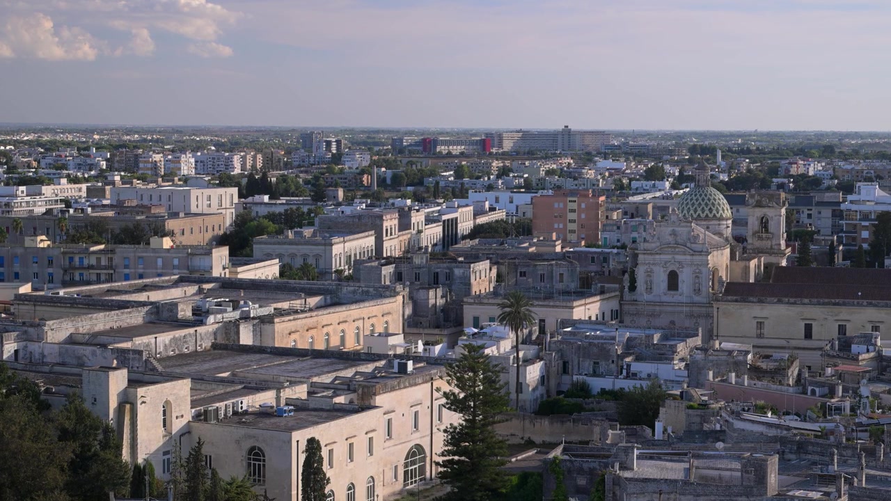 Vid solbelyst utsikt over Lecce-tak og kirkekuppel med moderne forsteder som strekker seg ut i det fjerne