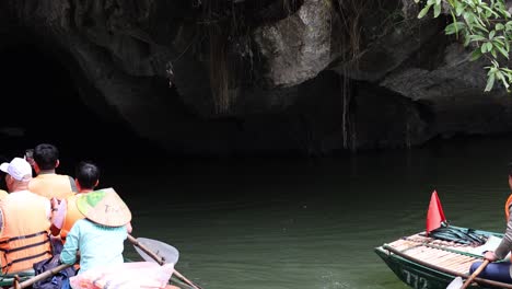 turistas remando en una cueva de piedra caliza oscura