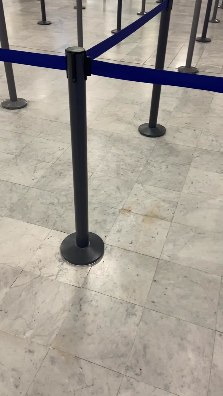 Empty airport terminal check in line with no passengers traveling abroad. Cancelled flights of airlines or closed off zone with blue ribbons separation of snake waiting zone departure or arrival gate