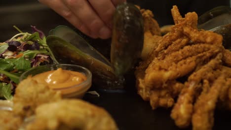 Slowmo---Plato-De-Acabado-Del-Chef-Mejillones-De-Concha-Verde-De-Nueva-Zelanda-En-Un-Plato-Con-Ensalada-Verde,-Ostras-Y-Salsa---Cerrar