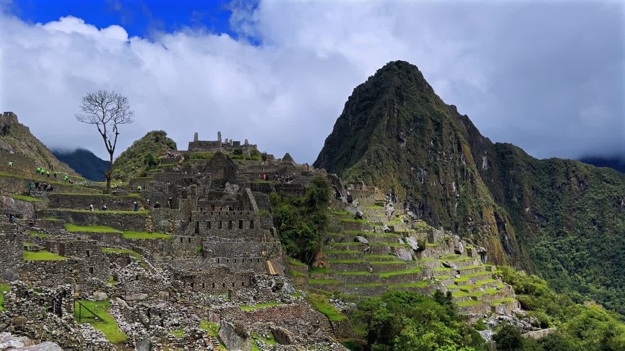 Machu Picchu, trasa pierwsza, poranek, drzewo shihuahuaco, Peru, widok z lotu ptaka, słonecznie, błękitne niebo, chmury, pora deszczowa, bujna zielona dżungla, góra Huayna Picchu, peruwiańskie Andy, świątynia Inków, trasa