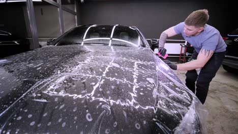 man covering car with vinyl polyurethane tape. films for the car. sticker protective film on the car