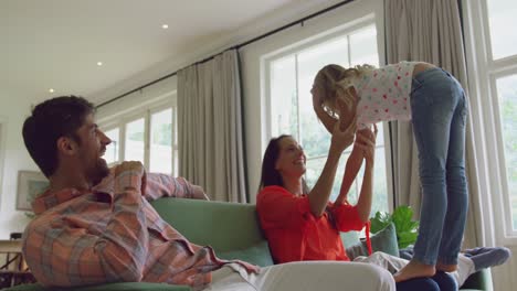 family playing together on sofa in living room at home 4k