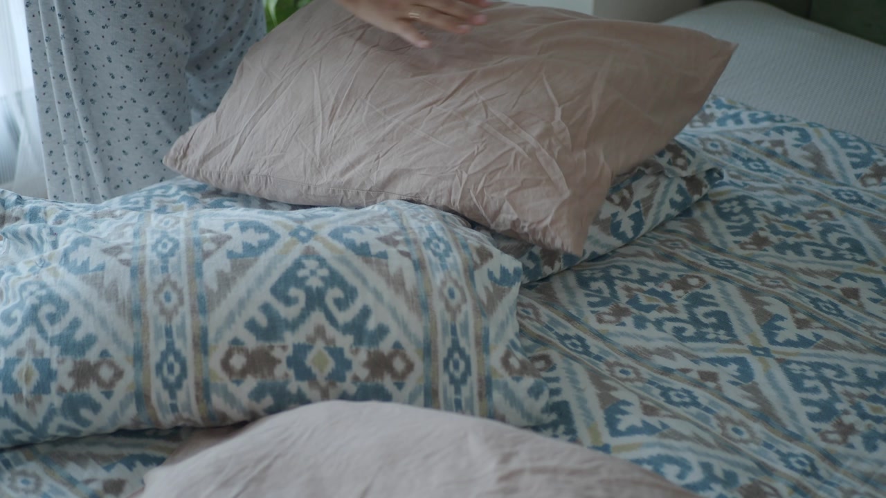 Close-up of Hands Fluffing Pillows and Making a Bed