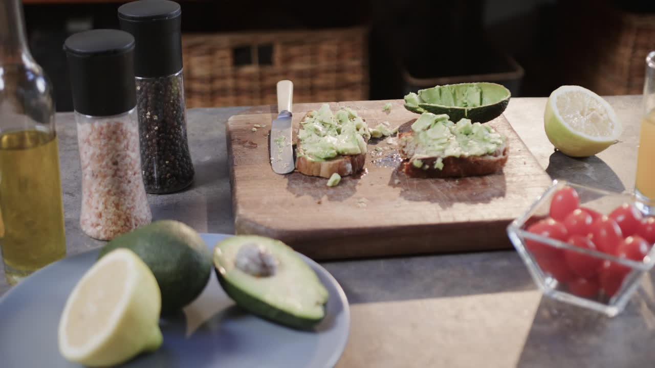 primer plano de tostadas de aguacate, verduras y jugo en la cocina, cámara lenta