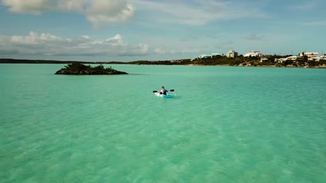 riding a boat alone on shallow waters close to a tropical beach on turks and caicos island