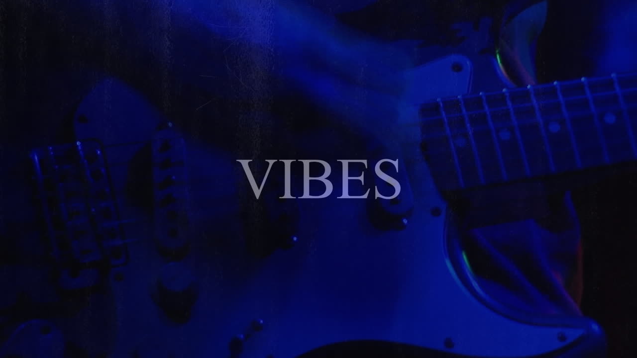 Animazione del testo "Belle vibrazioni" su una persona che suona la chitarra