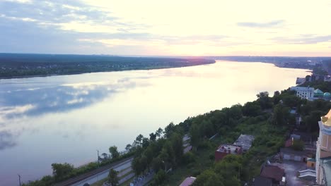 aerial view of a church by a river at sunrise