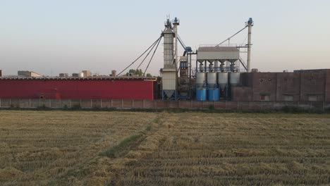 Drone-view-of-a-flour-mill-and-agricultural-field-in-Pakistan,-village-life-in-Pakistan