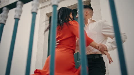 couple dancers enjoy latino style choreography performing near street railings.