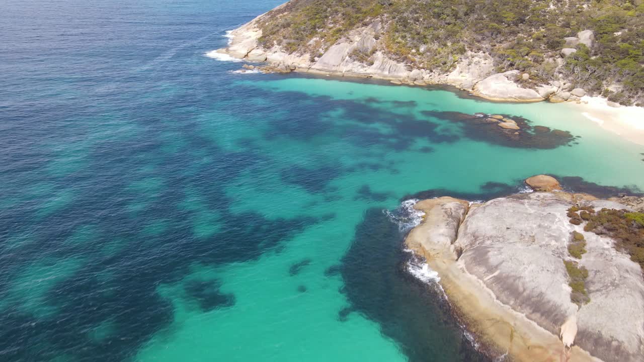 Drone aereo che si muove verso una spiaggia isolata con acqua blu brillante in Australia.
