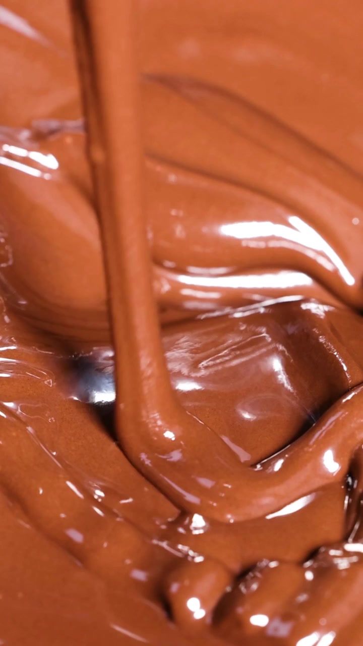 Cioccolato fuso e liscio che viene mescolato e versato