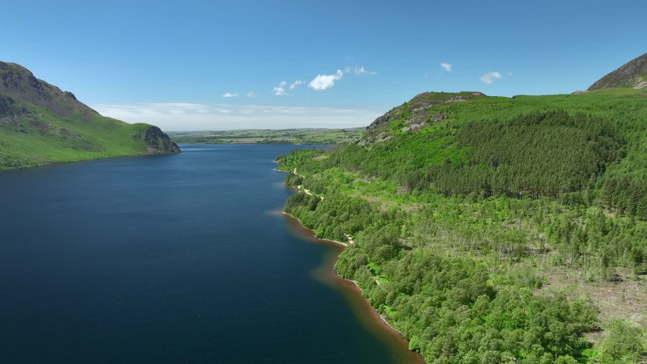 lago azul oscuro con costa montañosa boscosa y valle abierto
