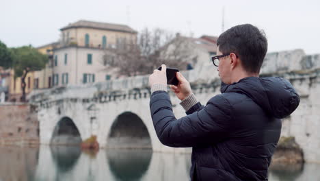 tourist taking picture of a bridge in italy