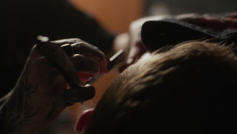 tattooed barber giving a haircut
