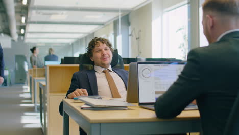 office workers chatting at desks during workday
