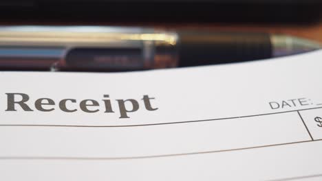 close-up of a receipt with a pen in the background