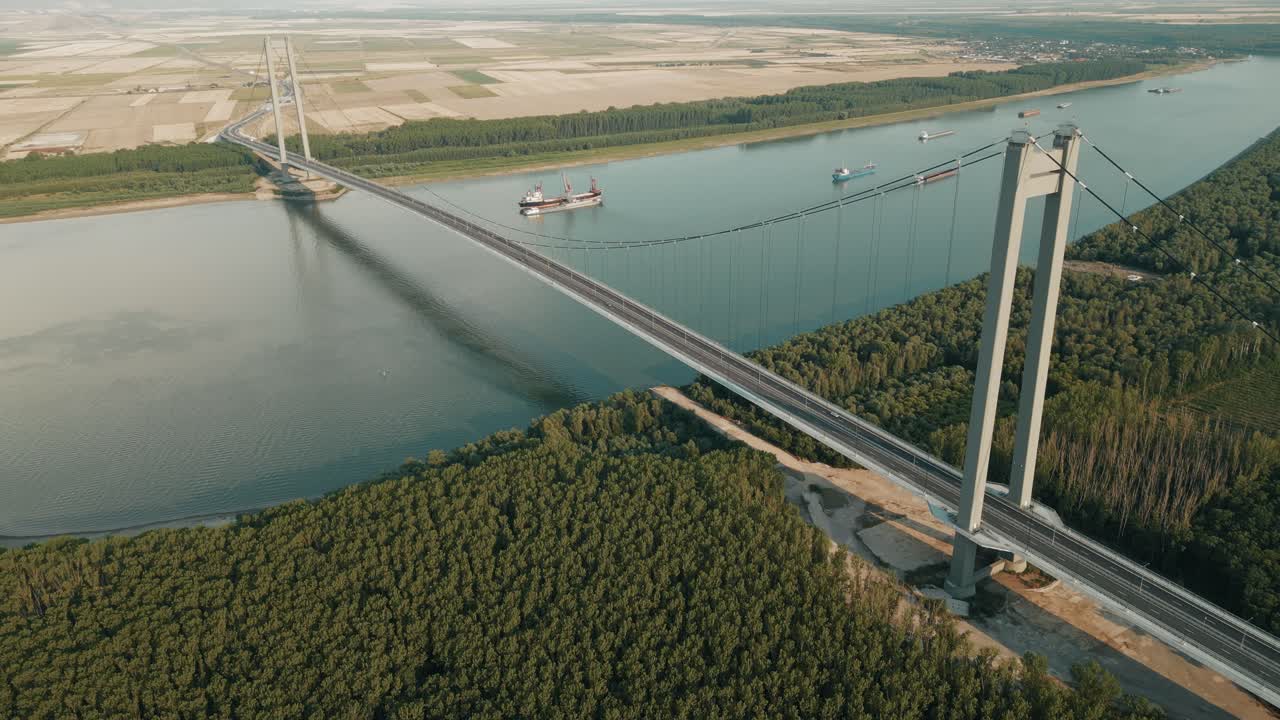 Industrial Ship Across The Danube River With Braila Bridge In Galati, Romania. Aerial Pullback Shot