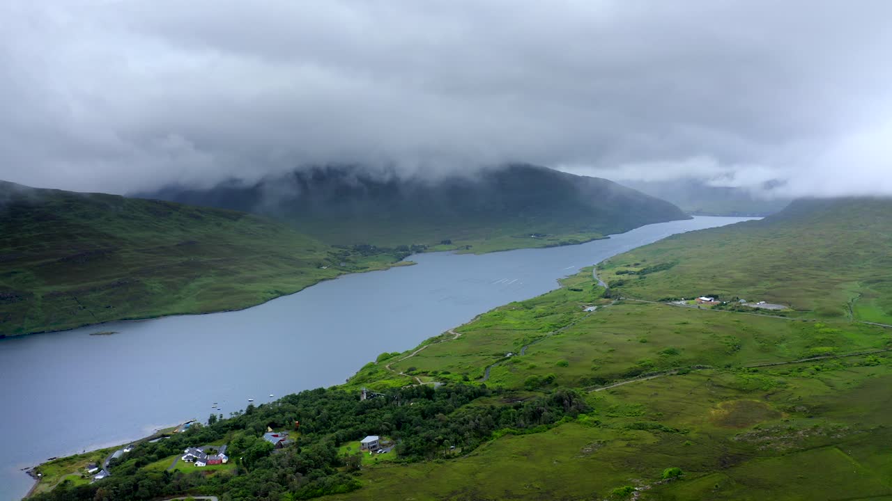 Killary Fjord, Leenane, Connemara, County Galway, July 2021. Drone faces east towards Leenaun village while slowly tracking north as low-hanging clouds drift across the mountains