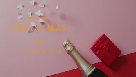 Animation-of-happy-new-year-text-over-champagne,-hearts-and-red-present