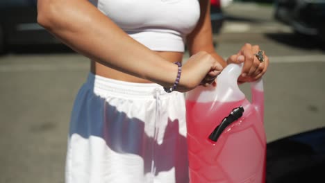 Woman refilling car fluid