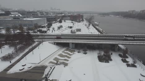 drone video of cars, road and snowy riverside near vistula, in warsaw poland