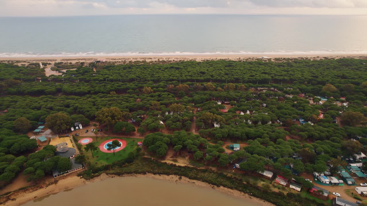 스페인 후엘바 해변에서 관광객을 위한 재미있는 공원이 있는 작은 캠핑 정착지가 있는 해변의 전경