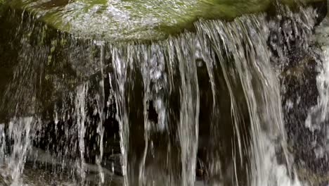 Agua-Rápida-Que-Fluye-Sobre-Rocas-En-La-Montaña