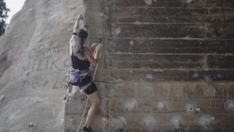 woman firmly climbing rocks at la foixarda barcelona in slow motion