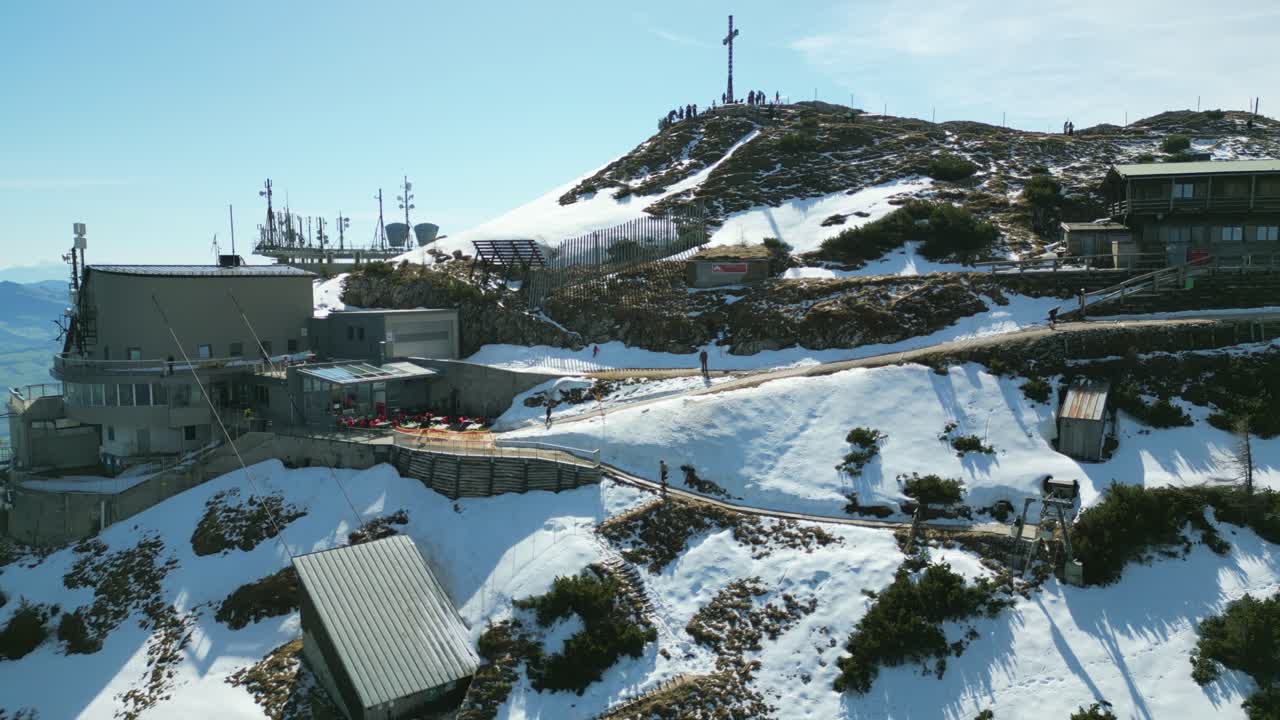 Rising drone shot over Untersberg, ascending past rocky slopes toward the summit station with the cable car, revealing Germany’s expansive Alpine panorama