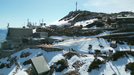 rising drone shot over untersberg, ascending past rocky slopes toward the summit station with the cable car, revealing germany’s expansive alpine panorama