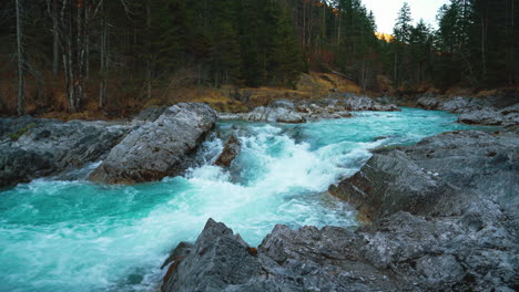 seamless video loop cinemagraph of a scenic and idyllic mountain river waterfall canyon with fresh blue water in the bavarian austrian alps, flowing down a beautiful forest along trees and rocks