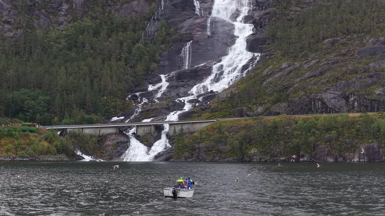 Cascata Langfossen che scorre vicino a un peschereccio in un remoto paesaggio norvegese