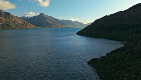 Panoramic-aerial-trucking-pan-across-shoreline-of-Lake-Wakatipu-into-center