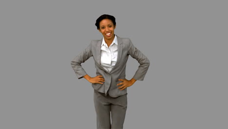 Cheerful-businesswoman-dancing-on-grey-screen