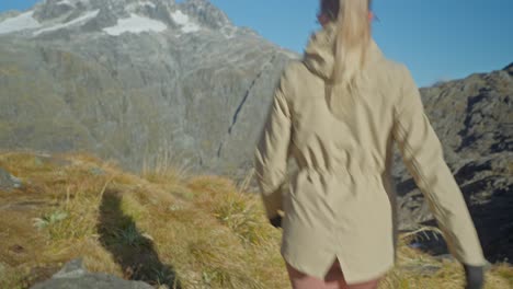 following blond womans legs towards viewpoint in rocky alpine landscape