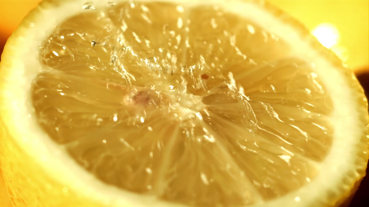 Schizzi d'acqua rinfrescanti su una fetta di limone giallo brillante.