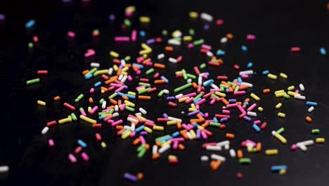 vibrant sprinkles cascade onto a dark background