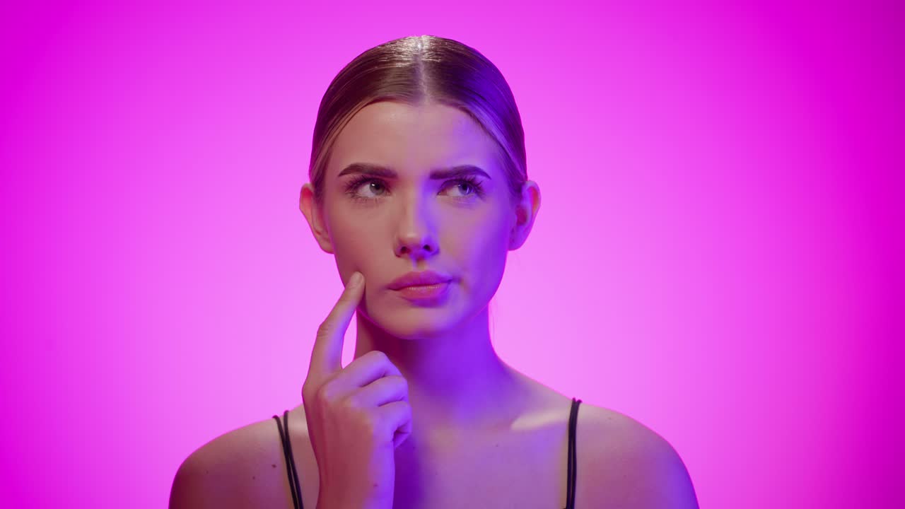 joven mujer rubia caucásica piensa y se pregunta cosas de cerca en el estudio