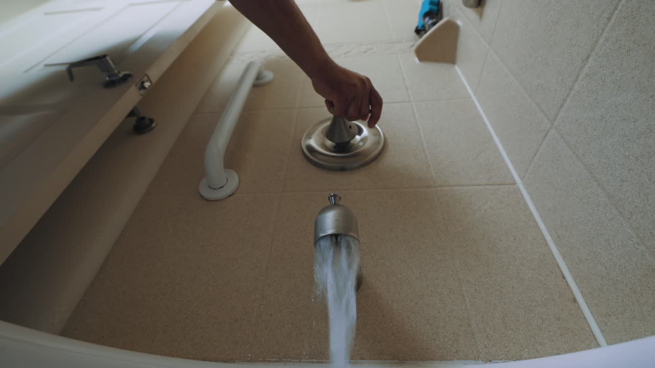 A man switches on a shower