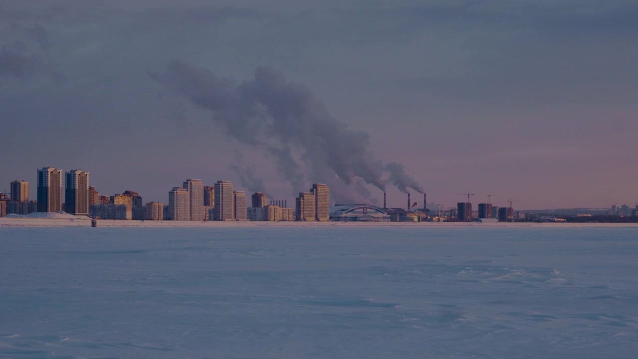 Frozen waterfront with snowy Russian skyline and industrial background